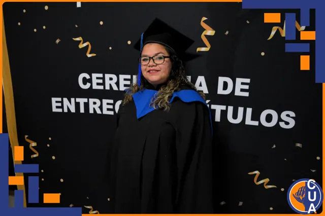 Graduada sonriente con lentes, birrete y estola azul posa en la ceremonia de entrega de títulos.