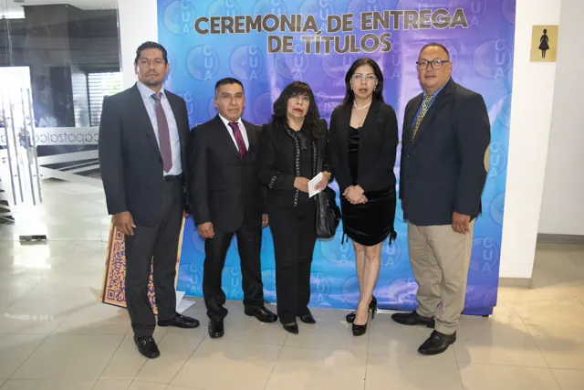 Grupo de asistentes frente al fondo de la ceremonia de graduación. Graduación del 7 de julio de 2025.