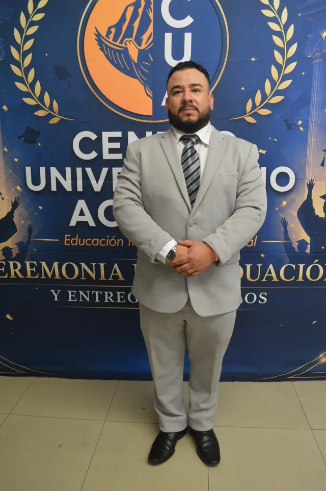 Participante con traje gris y corbata a rayas posa frente al fondo institucional de Acacias.