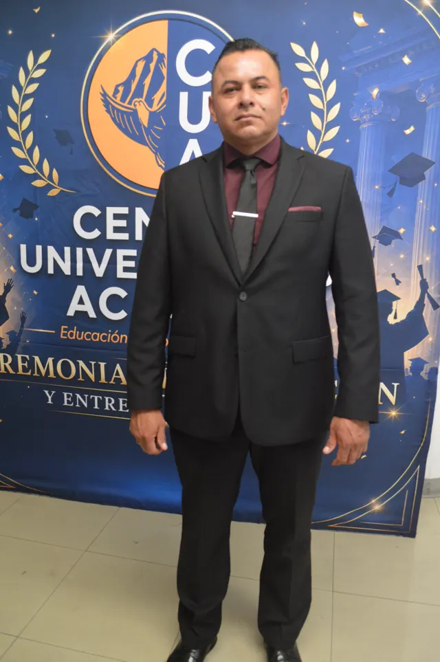 Participante con traje oscuro y camisa color vino posa frente al logotipo de Acacias.
