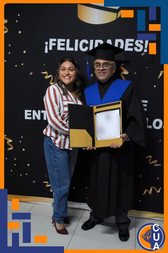 Graduado con toga y estola azul comparte su reconocimiento con una acompañante. Graduación del 14 de junio de 2025.